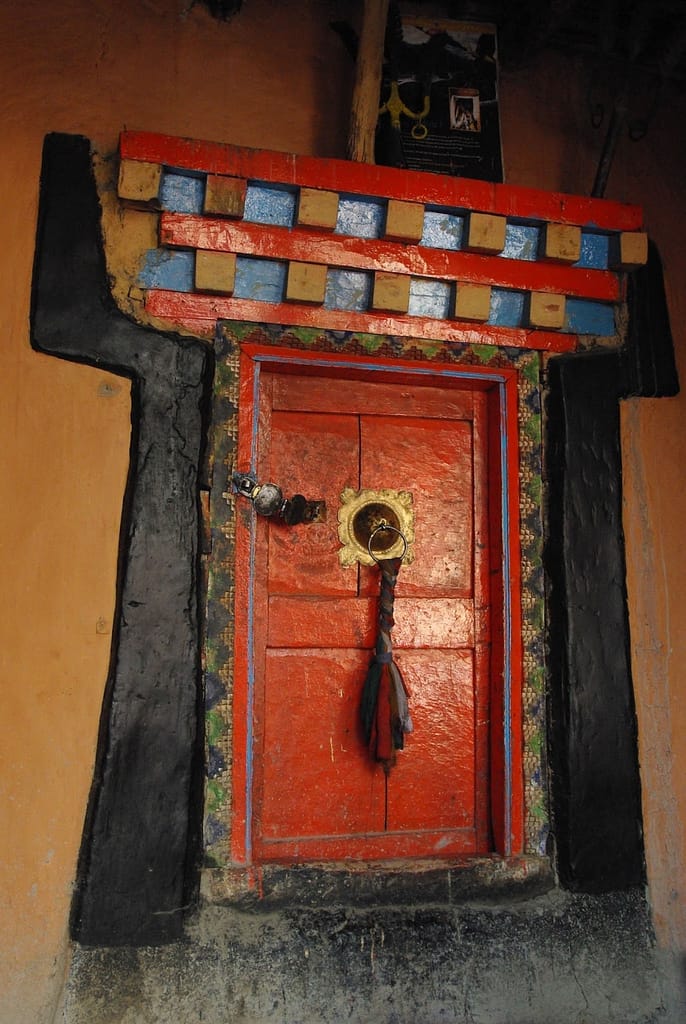 Porte rouge avec poignée en métal et décor traditionnel, Inde