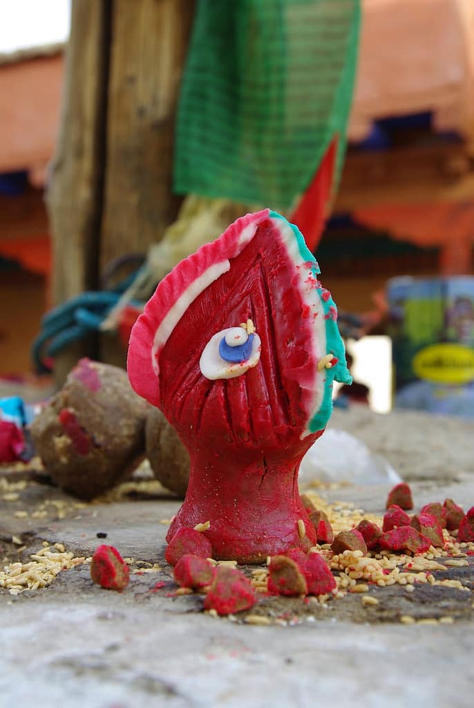 Petite offrande rituelle colorée déposée au sol, fragile et vibrante de symboles au cœur du quotidien (?)