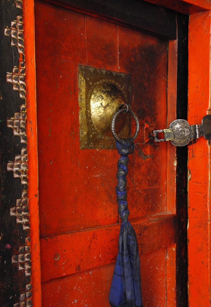 Porte rouge avec poignée en métal et décor traditionnel, Inde