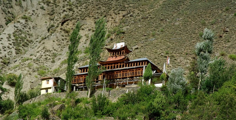 Monastère en bois accroché à flanc de montagne entouré d'arbre, Inde