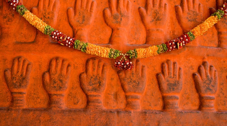 Mains sculptées et guirlande de fleurs temple, Inde