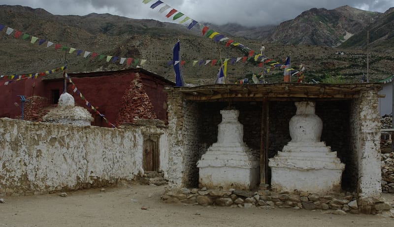 Stupas blanchis à la chaux dans un petit village de montagne décoré de drapeaux de prière (?)