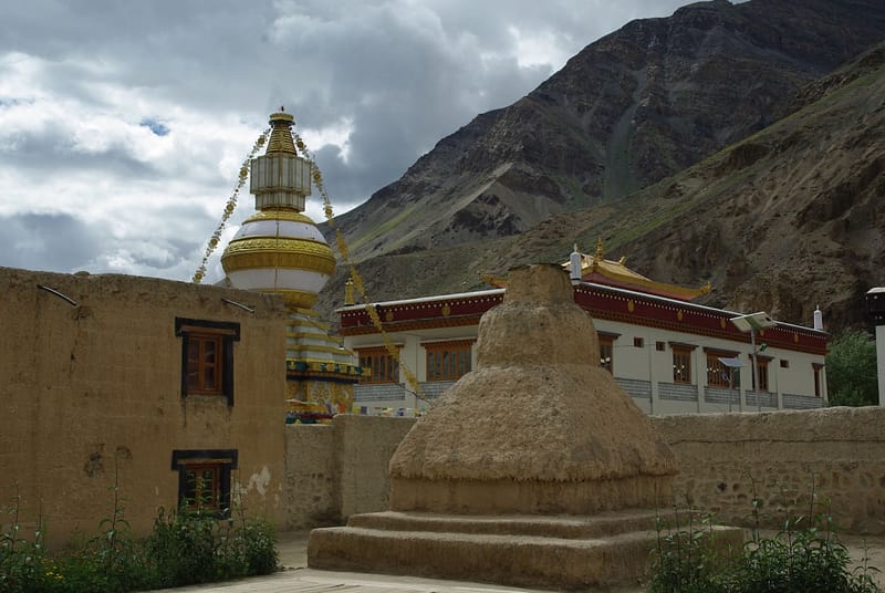 Stupa et temple dans un village de montagne avec paysage himalayen (?)