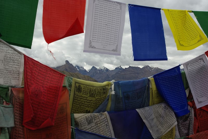 Drapeaux de prière colorés dans l’Himalaya avec montagnes en arrière-plan