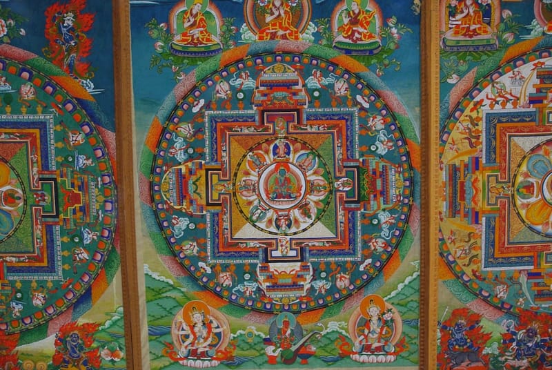 Mandala richement détaillé, éclat de couleurs et de symboles où se déploie une cosmologie sacrée minutieusement peinte (?)